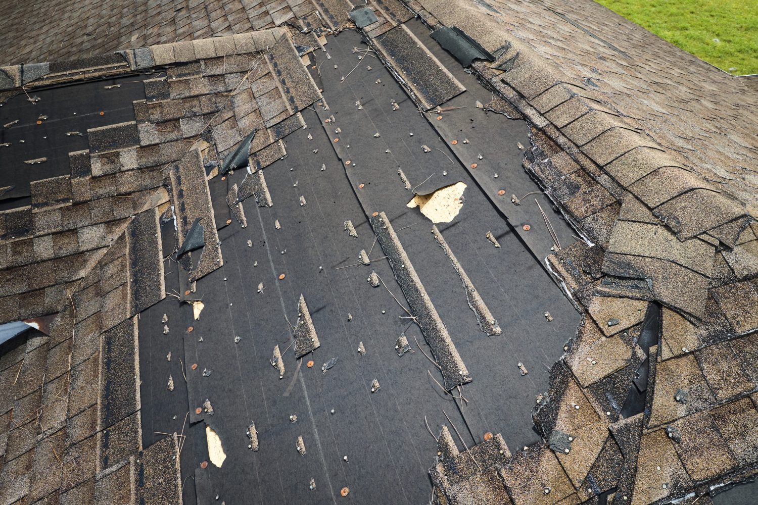 Damaged house roof with missing shingles after hurricane Ian in Florida. Consequences of natural disaster.